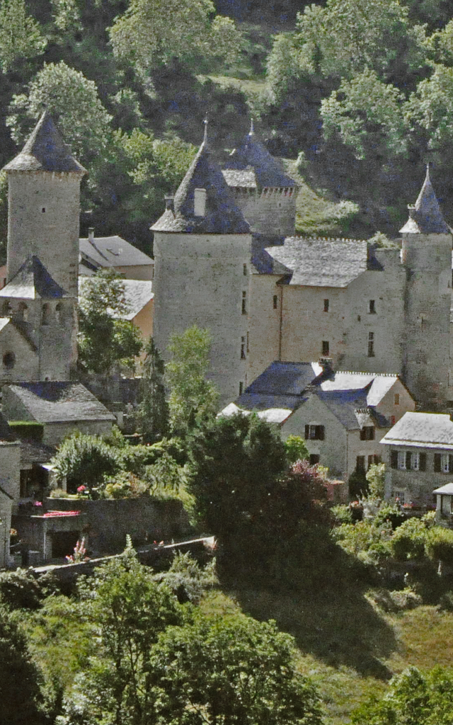 Saint Saturnin and its 14th-century castle at the foot of the Causse de Sauveterre cliffs in the Urugne valley.