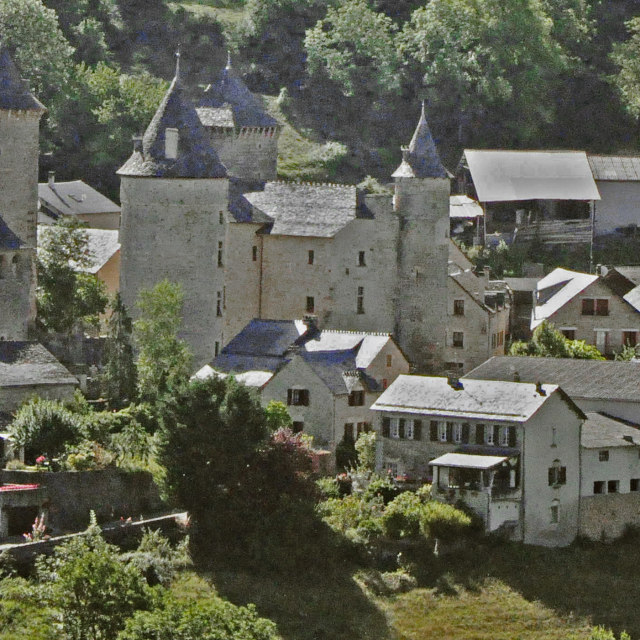 Saint Saturnin and its 14th-century castle at the foot of the Causse de Sauveterre cliffs in the Urugne valley.