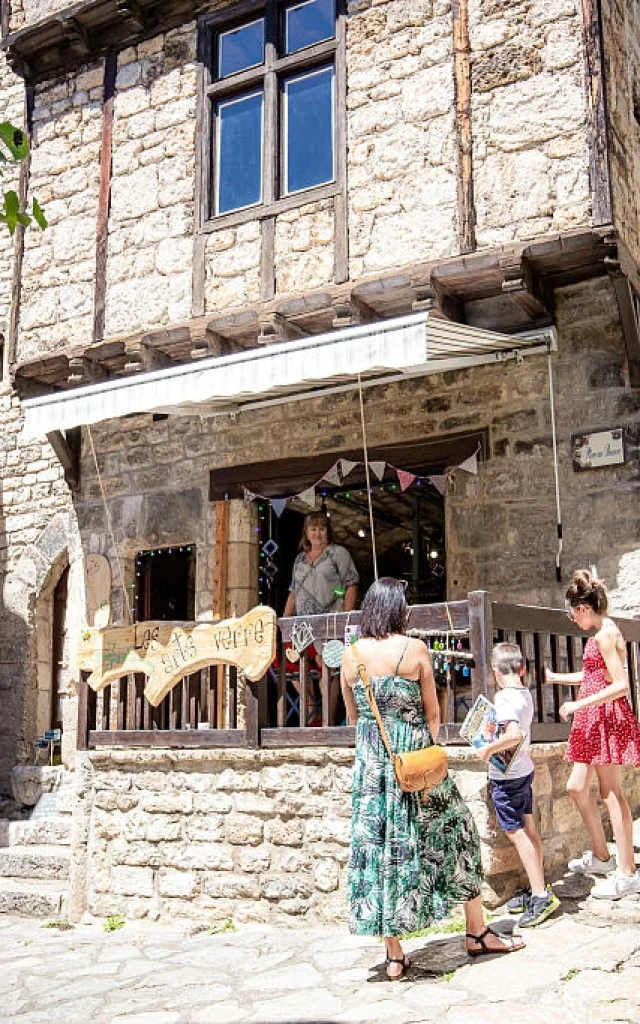 Une famille discute avec une commerçante de Sainte-Enimie